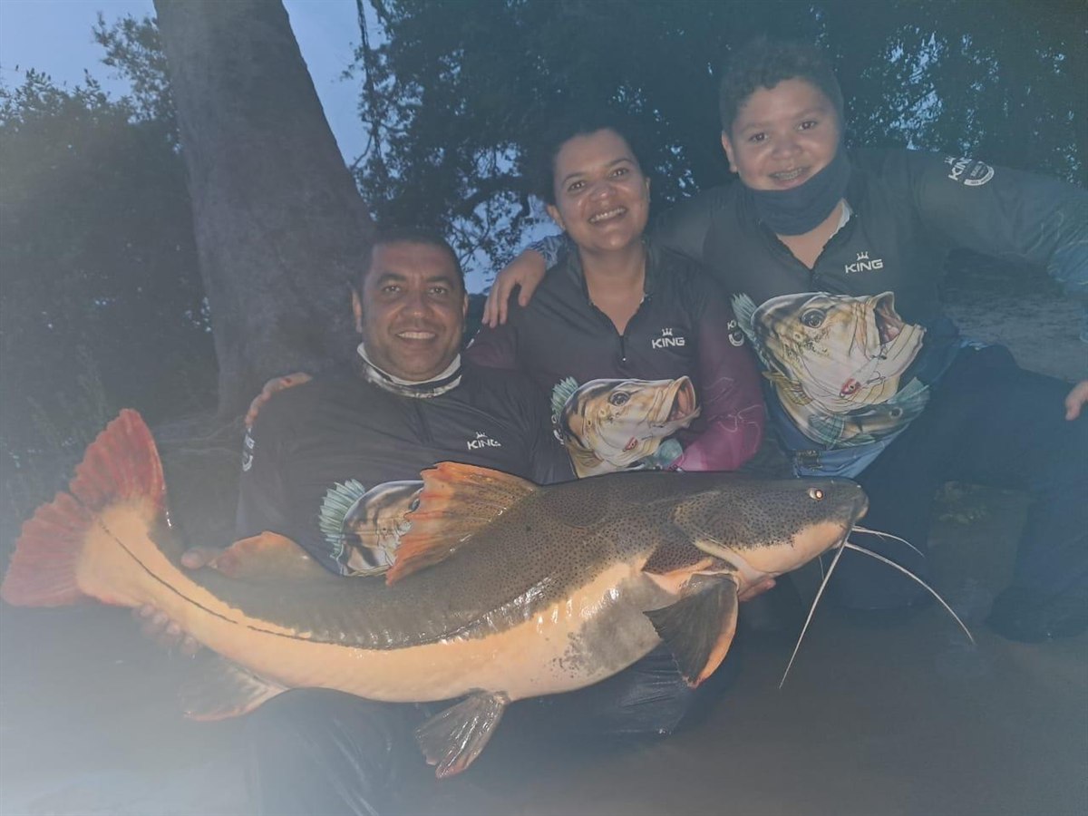 Família reunida com uma grande pirarara