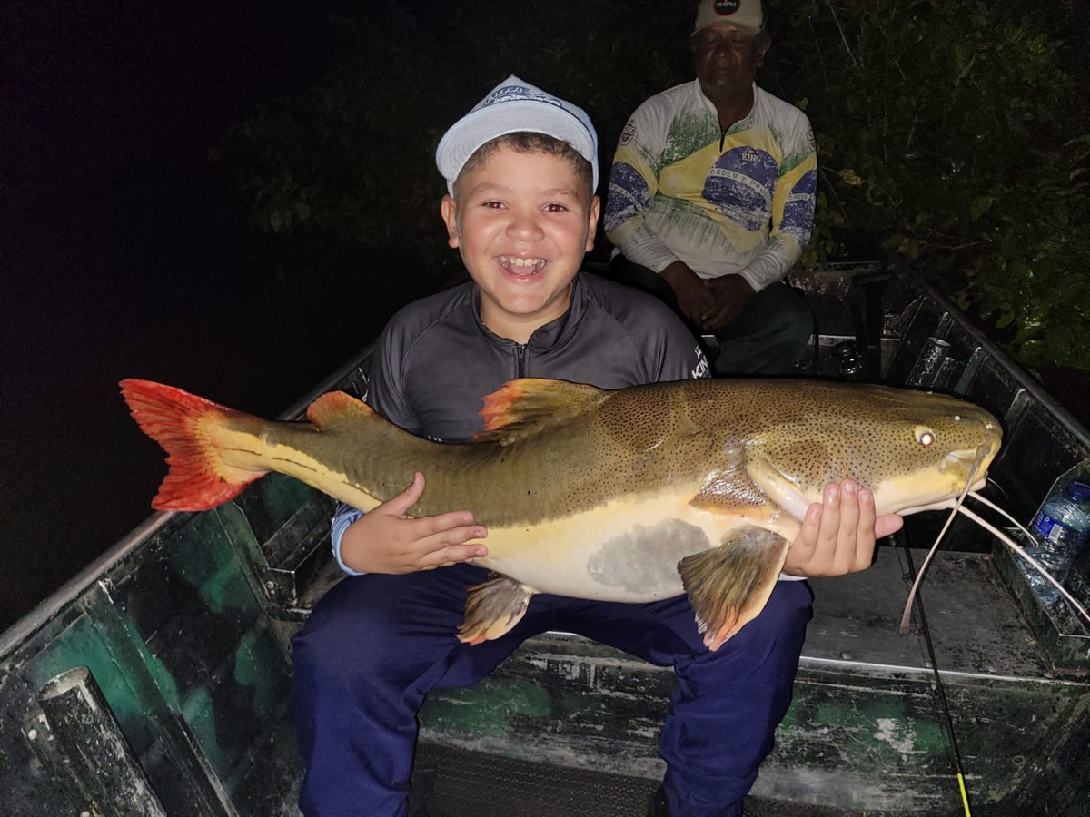 Jovem pescador com sua captura noturna