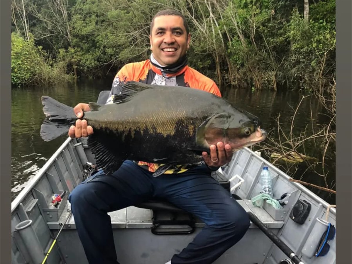 Pescador com espécie esportiva capturada no barco